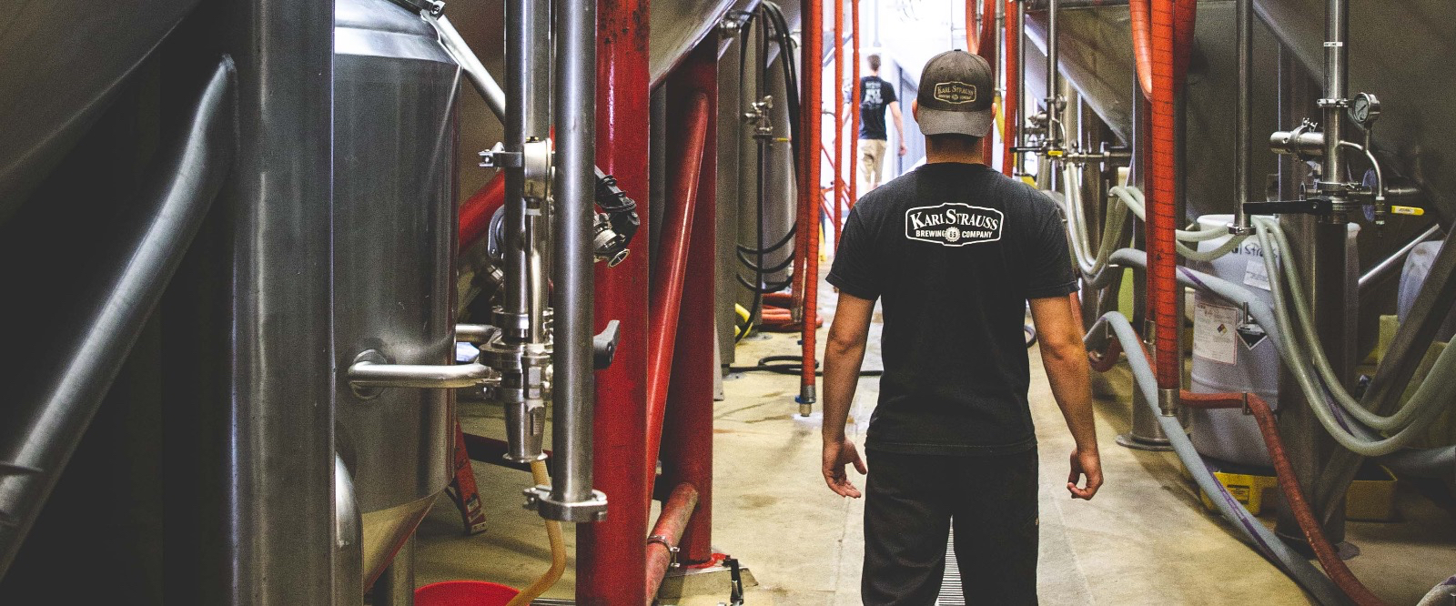 Man walking through brewing equipment